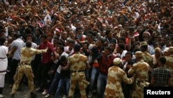 FILE - Demonstrators chant slogans and flash the Oromo protest gesture during Irreecha, the thanksgiving festival of the Oromo people, in Bishoftu town, Oromia region, Ethiopia. 