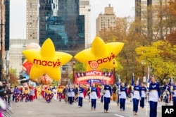 Performers and balloons pass through 59th Street during the Macy's Thanksgiving Day Parade on Thursday, Nov. 24, 2016, in New York. (Photo by Scott Roth/Invision/AP)