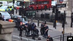 Police arrest a man on the pavement in Whitehall, London, April 27, 2017. London police say they have arrested a man for possession of offensive weapons near Britain's Houses of Parliament. Police raids in London and southeastern England were unrelated, police said. 