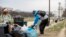 The Capitol building is visible as a man who declined to give his name picks up garbage and stacks it near a trash can during a partial government shutdown on the National Mall in Washington, Dec. 25, 2018. 