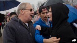 FILE - A supporter of Republican presidential candidate Donald Trump, left, and a protester argue before the candidate's arrival at the Savannah Center, March 13, 2016, in West Chester, Ohio.