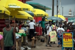 Street vendors use parasols reading "Abobo ADOland" in reference to the Ivory Coast President Alassane Ouattara, who is known as ADO, at Abobo neighborhood in Abidjan, Ivory Coast, Nov. 2, 2020.