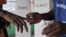 A National Elections Commission official puts indelible ink on the finger of a voter at a polling station during a runoff election between Liberian President George Weah and former Vice President Joseph Boakai, in Monrovia, Liberia, on Nov. 14, 2023.
