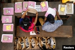 Election officials sit next to election materials to be distributed to polling stations at a distribution center, ahead of the third phase of general elections in Kochi, India, April 22, 2019.