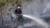 A member of the military works to contain a wildfire on a field in Indralaya, South Sumatra, Indonesia, Sept. 16, 2015.