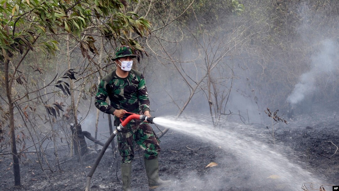 Seorang tentara menyemprotkan air untuk memadamkan api di Indralaya, Sumatra Selatan (16/9).