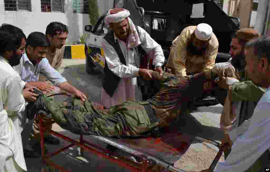 People carry a wounded security officer to a hospital in Quetta, Pakistan, &nbsp;August 8, 2013.