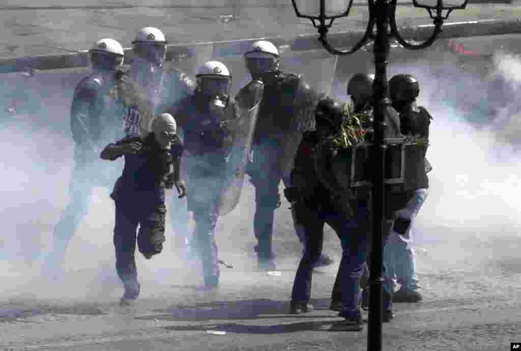 İğtişaş polisi Afinada toqquşmalar zamanı maska geymiş nümayişçiləri həbs etməyə cəhd göstərir