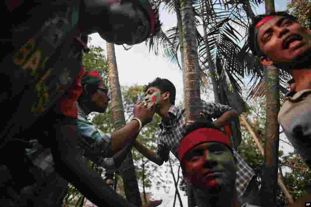 Penggemar kriket Bangladesh mengecat wajahnya dengan warna-warna bendera nasional Bangladesh dalam sebuah acara untuk mendukung tim nasional mereka di Kampus Universitas Dhaka di Dhaka. Bangladesh akan bermain melawan India di perempat final Piala Dunia pada 19 Maret.