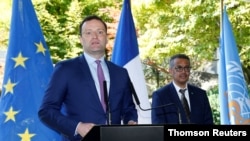 Germany's Federal Minister of Health Jens Spahn, flanked by Tedros Adhanom Ghebreyesus, director-general of the World Health Organization, speaks during a news conference in Geneva, Switzerland, June 25, 2020.