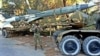 FILE - An undated picture posted on the Facebook page of a militant group shows a member of Mujahidin, who fight with Syrian rebels groups against government forces, next to a missile at an unknown place in Syria.