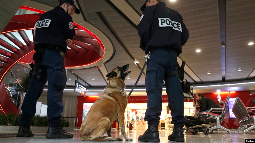 Polisi dengan anjing pelacak berjaga-jaga di dalam terminal 1 bandar udara Charles de Gaulle di Paris (19/5). (Reuters/Christian Hartmann)