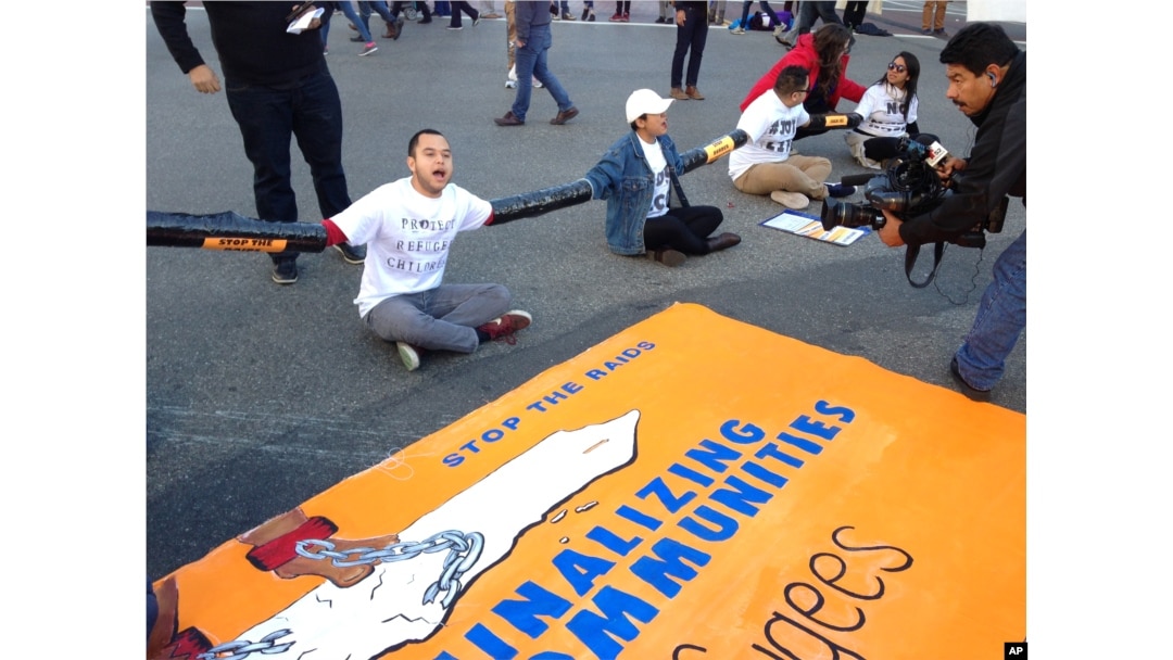 FILE - Immigration activists participate in a sit-in protest against the raids and deportation of immigrants near the downtown Los Angeles Federal Building, Jan. 26, 2016.