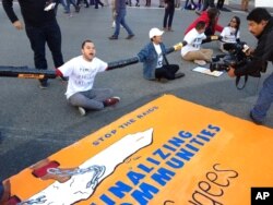 FILE - Immigration activists participate in a sit-in protest against the raids and deportation of immigrants near the downtown Los Angeles Federal Building, Jan. 26, 2016.