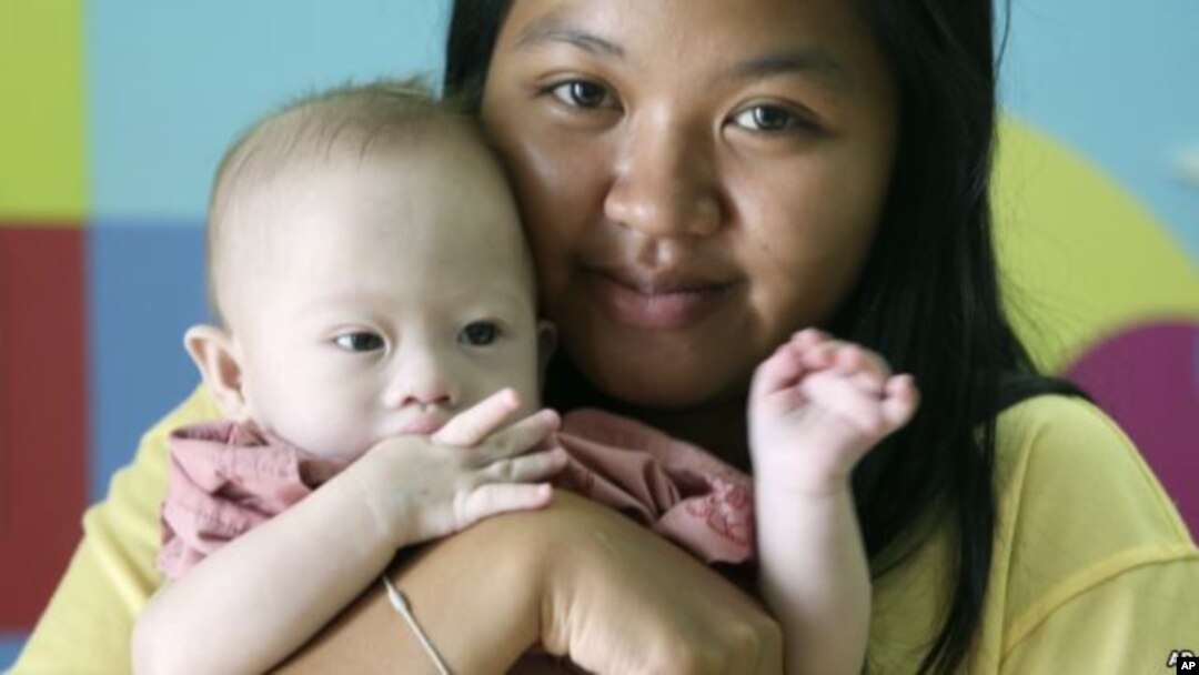Pattaramon Chanbua (21) berpose dengan bayinya di salah satu rumah sakit di provinsi Chonburi, Thailand, 3 Agustus 2014 (Foto: dok). Parlemen yang ditunjuk militer Thailand telah meluluskan sebuah undang-undang yang mengkriminalisasikan komersialisasi proses melahirkan anak lewat ibu tumpang (surogasi).