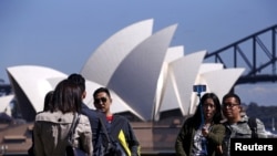 FILE - Chinese tourists taking pictures of themselves in front of the Sydney Opera House in Sydney, Australia.