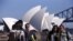 FILE - Chinese tourists taking pictures of themselves in front of the Sydney Opera House in Sydney, Australia.