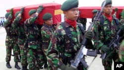 Indonesian soldiers carry the coffins of their colleagues who were killed in a clash with separatist rebels in Papua province upon arrival at Juanda airport in Surabaya, East Java, Indonesia, Tuesday, April 11, 2006. 