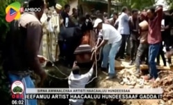 In this image taken from OBN video, the coffin carrying Ethiopia singer Hachalu Hundessa is lowered into the ground during the funeral in Ambo, Ethiopia, Thursday July 2, 2020.