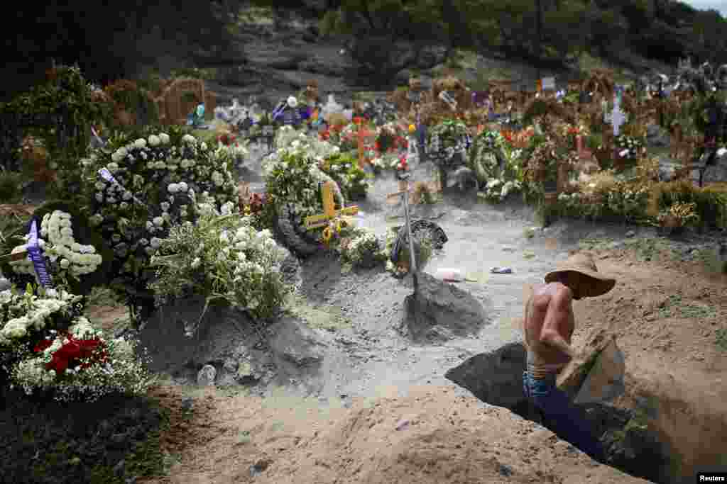 A cemetery worker dig a new grave at the Xico cemetery on the outskirts of Mexico City, as the coronavirus disease (COVID-19) outbreak continues, June 10, 2020.