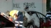 This frame grab from video provided by the Australian Broadcast Corporation Dec. 11, 2024, shows a police officer walking past a torched car being removed from in front of anti-Israel graffiti on a wall in a Sydney suburb (image partially blurred by VOA).