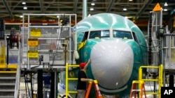 Seorang teknisi memeriksa bagian hidung dari pesawat Boeing 737 MAX yang diproduksi di Renton, Washington, pada 7 Desember 2015. (Foto: AP/Ted S. Warren)