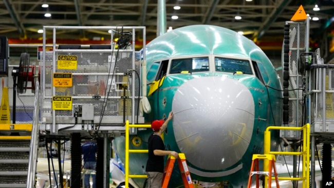 FILE - In this Dec. 7, 2015, photo, a worker inspects the nose cone of the second Boeing 737 MAX airplane being built in Renton, Wash.