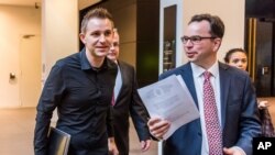 FILE - Max Schrems (L) and his lawyer, Herwig Hofmann, are seen walking in a hallway of the European Court of Justice in Luxembourg on Oct. 6, 2015.