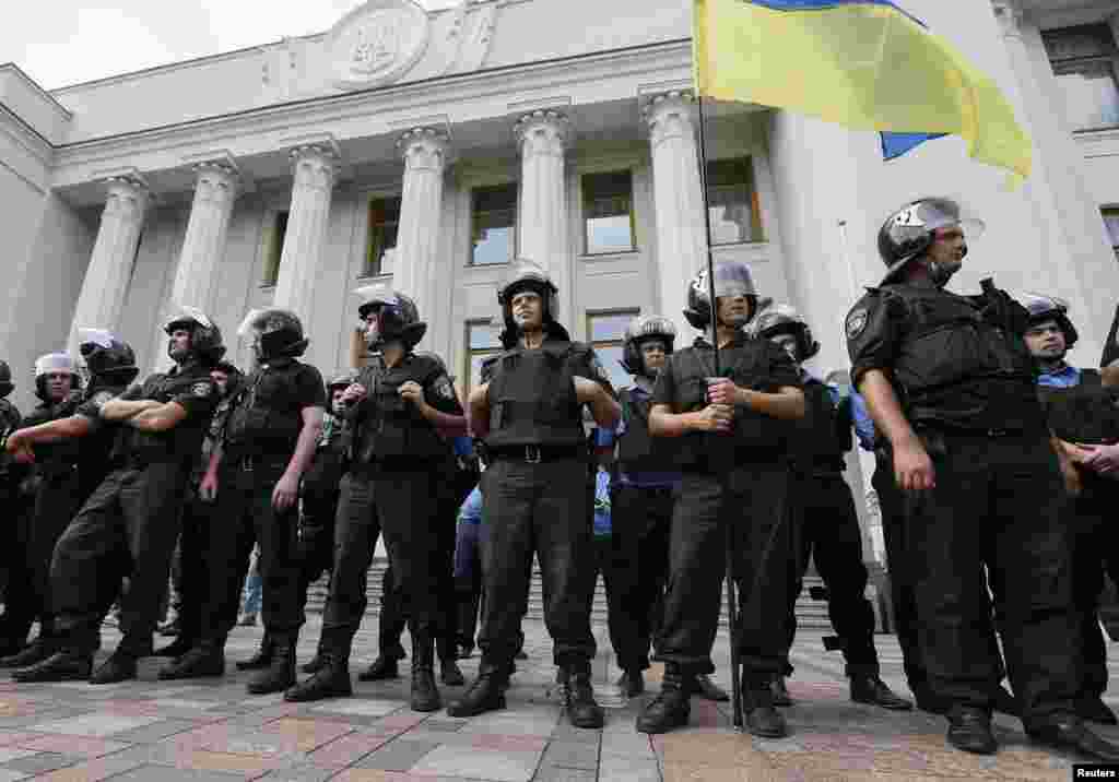 Police stand guard during a rally in front of the parliament building in Kyiv, August 12, 2014.
