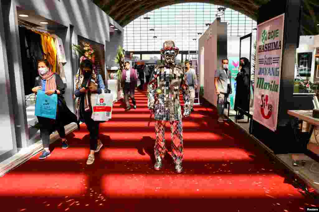 A man wears a suit made of mirrors at a fashion and clothing exhibition in Tehran, Iran.