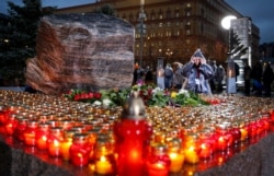 FILE - Flowers and candles are placed at a memorial in Moscow, Russia, Oct. 29, 2019, during a commemoration of victims of Joseph Stalin's purges.