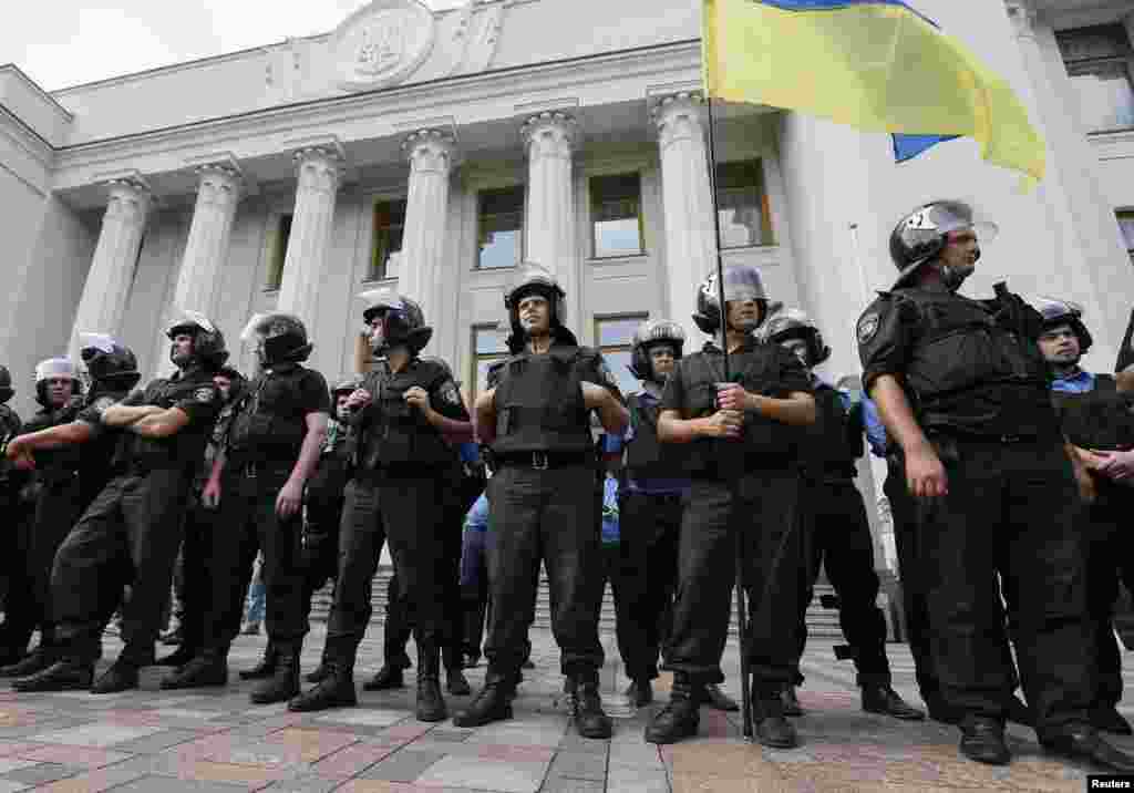 Police stand guard during a rally in front of the parliament building in Kyiv, Aug. 12, 2014.