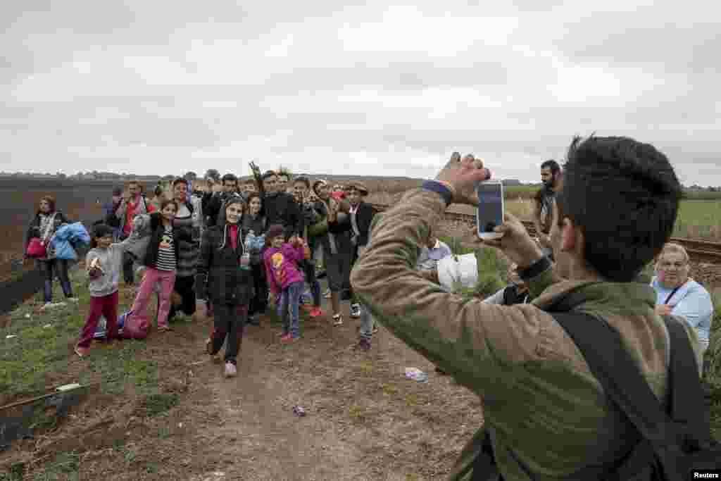 Alvand, 18, dari Kobani, Suriah, memotret kawan-kawannya saat mereka berjalan menyusuri rel kerata api setelah menyeberang ke Hungaria lewat perbatasan Serbia dekat desa Roszke (5/9). &nbsp;(Reuters/Marko Djurica)