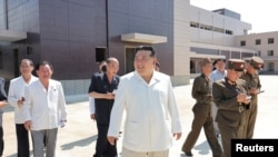 Pemimpin Korea Utara Kim Jong Un tersenyum saat mengunjungi lokasi pembangunan berbagai pabrik industri Korea Utara pada Sabtu dan Minggu, di lokasi yang dirahasiakan di Korea Utara, 26 Agustus 2024. (Foto: KCNA via REUTERS)