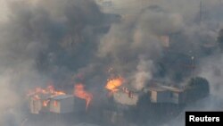 A fire burns houses on a hill, where more than 100 homes were burned due to a forest fire, but there have been no reports of death, local authorities said in Valparaiso, Chile, Jan. 2, 2017. 