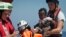 Rescuers put a life jacked on a child during a search and rescue operation conducted by SOS Mediterranee and MSF (Doctors Without Borders) NGOs, in the Mediterranean Sea, north of Libyan coast.