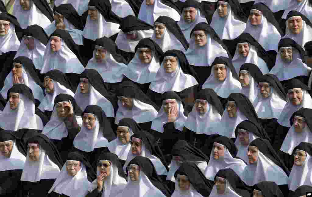 Nuns pray during a canonization ceremony in St. Peter&#39;s Square at the Vatican. Pope Francis canonized the Catholic Church&#39;s first married couple in modern times, declaring the parents of the beloved St. Therese of Lisieux saints in their own right.