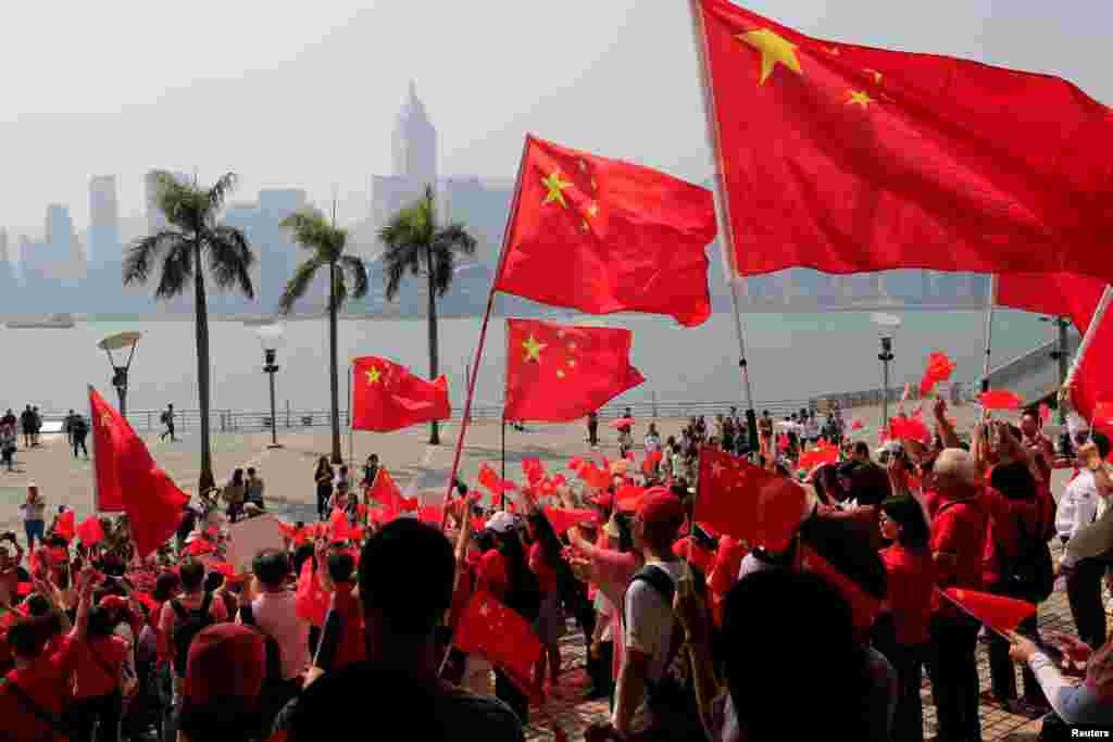 Pro-China supporters hold up Chinese national flags facing Victoria Harbour during a rally in Hong Kong, China.