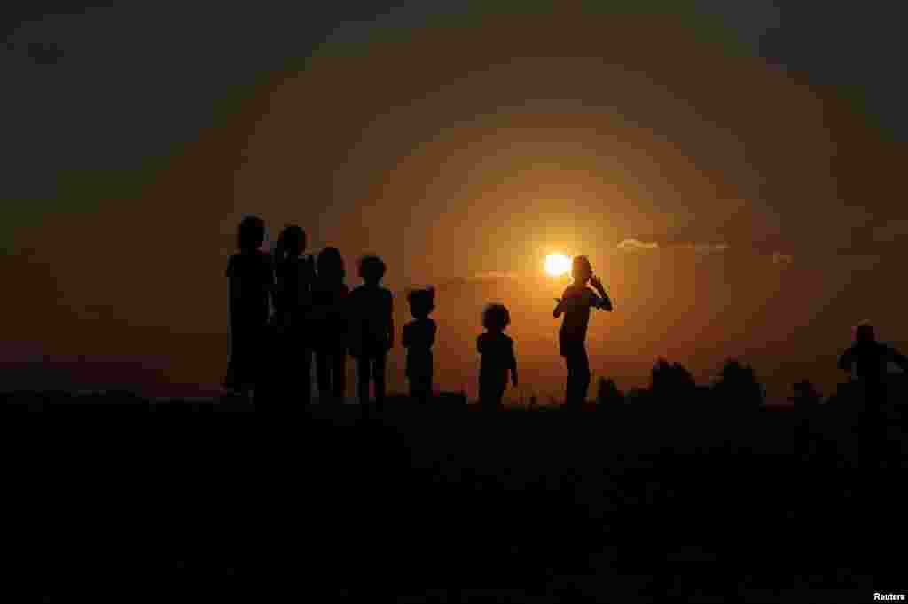 Palestinian children gather after a local horse race on the land of Gaza destroyed airport, in Rafah in the southern Gaza Strip.