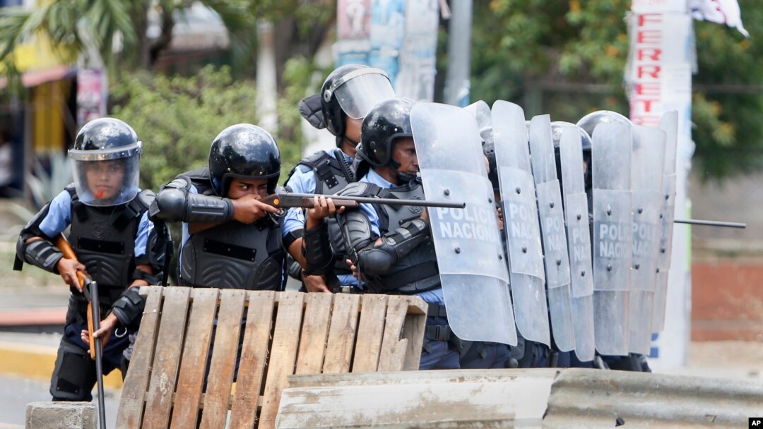 Pasukan keamanan mengarahkan senjatanya ke arah para demonstran mahasiswa dalam protes yang rusuh di Managua, Nikaragua (20/4).