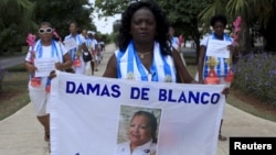 រូបឯកសារ៖ អ្នកស្រី Berta Soler មេដឹកនាំ​ក្រុម​ចលនា The Ladies in White ដែល​ជាក្រុម​ប្រឆាំង កាន់បដា​ដែល​មាន​រូប​ស្ថាបនិក​ចលនា​នេះ គឺ​អ្នកស្រី Laura Pollan ក្នុង​អំឡុងពេល​បាតុកម្ម​ប្រឆាំង​រដ្ឋាភិបាល​ប្រចាំ​សប្តាហ៍​នៅ​ទីក្រុង Havana។
