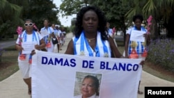 Berta Soler, leader of The Ladies in White, an opposition group, carries a banner with an image of the founder of movement, Laura Pollan, during their weekly anti-government protest in Havana. (File)