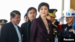 Thailand Prime Minister Yingluck Shinawatra (C) arrives at the Royal Thai Air Force headquarters before a cabinet meeting in Bangkok, Feb. 11, 2014. 