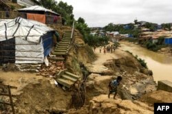 Rohingya children walk around a landslide area at Balukhali refugee camp in Ukhia, July 7, 2019. Monsoon-triggered landslides in Rohingya refugee camps in Bangladesh have killed one person and left more than 4,500 homeless, said officials said.