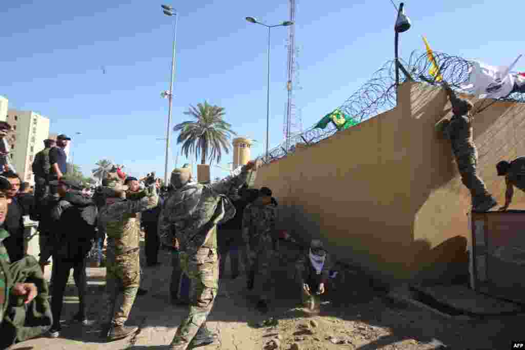 Miembros del grupo Hash al-Shaabi en el muro que separa la embajada de Estados Unidos, situada en un lugar denominado &quot;Zona Verde&quot; (Foto: AFP/Ahmad Al-Rubaye)