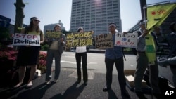 A group of people state a protest against climate change and coal investments, ahead of the G7 Finance Ministers and Central Bank Governors' Meeting, in front of the Ministry of Finance in Tokyo on May 19, 2016.