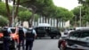 Police officers stand in front of a synagogue, in background on the right, following the fire and explosion of cars in La Grande Motte, France, on Aug. 24, 2024.