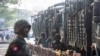 FILE - Soldiers stand next to military vehicles in Yangon, Myanmar, February 15, 2021.