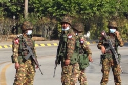 Soldiers stand guard on a street in Naypyidaw on February 1, 2021, after the military detained the country's de facto leader Aung San Suu Kyi and the country's president in a coup.