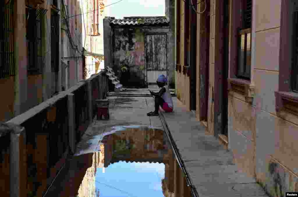 Una mujer se sienta afuera de su casa después de que le entregaran agua durante la escasez de agua, en La Habana, Cuba, el 11 de septiembre de 2024.